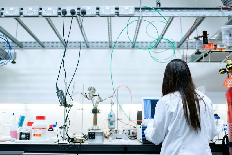 A researcher in a lab coat working at an instrumented laboratory bench