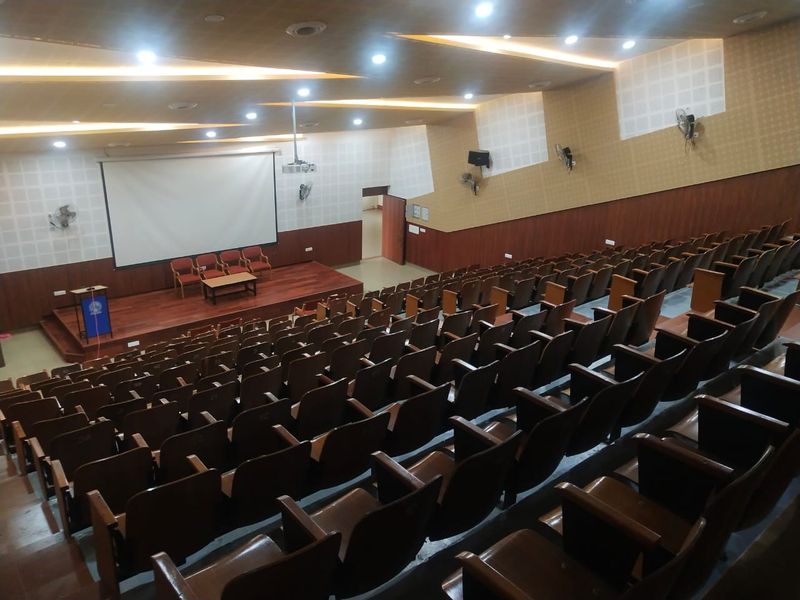 The placement seminar hall, empty, screen lowered over the podium
